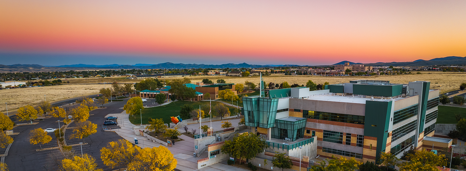 Aerial sunset view of Prescott Valley, Arizona showing modern buildings, open spaces, and distant mountains